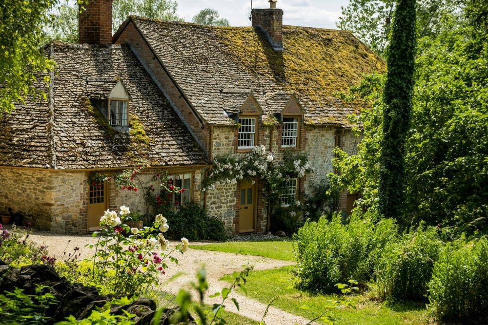 Two storey cottage in Cotswolds with greenery foreground.